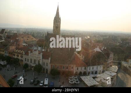 Sibiu, Rumänien. Blick über den kleinen Platz vom Rathausturm. Die Altstadt mit den angrenzenden Gebäuden und der lutherischen Kathedrale im Hintergrund. Stockfoto