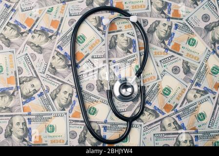 Teure medicare oder Welt global wirtschaftlichen Zusammenbruch Konzept. Oben oben oben oben oben oben oben Foto von doc Stethoskop, das auf Stapel von uns Geld liegt Stockfoto