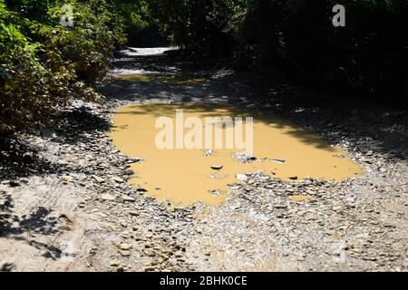 Eine große Pfütze auf einer unbefestigten Landstraße. Stockfoto