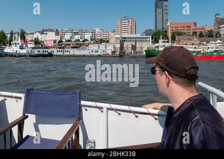 Ein männlicher Tourist auf einer Flusskreuzfahrt durch die Stadt und den Hafen von Hamburg Stockfoto