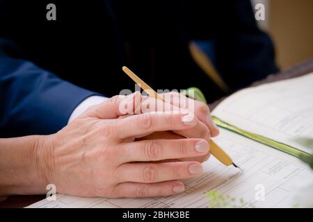 Ein älteres Paar heiratet und unterschreibt das Hochzeitsbuch Stockfoto