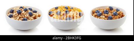 Drei Schüsseln aus verschiedenen Getreidearten mit frischen Blaubeeren auf weißem Hintergrund isoliert Stockfoto