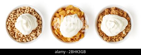 Drei Schüsseln mit verschiedenen Cerealien mit Joghurt isoliert auf weißem Hintergrund, Draufsicht Stockfoto