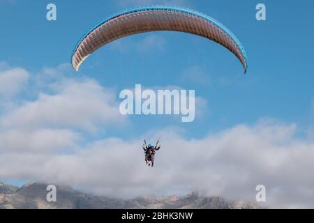 Gleitschirm mit Instruktor Pilot im Tandem am Himmel über den Bergen über Costa Adeje, Teneriffa Stockfoto