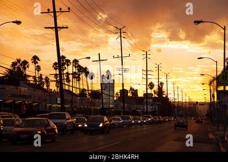 Auf dem Santa Monica Boulevard in Hollywood, Los Angeles, Kalifornien, standen Autos mit einem spektakulären Sonnenuntergang auf dem Straßenlärm Stockfoto