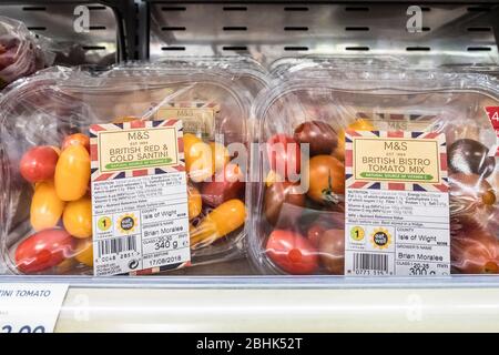 In Kunststoff verpackte Spezialtomaten, die in einem Kühlschrank in einem M&S Food Supermarkt gelagert werden. Stockfoto