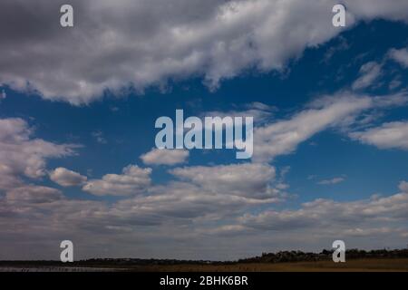 Wolkiger dramatischer Himmel mit einem schmalen Horizont unten. Kreativer Vintage-Hintergrund Stockfoto