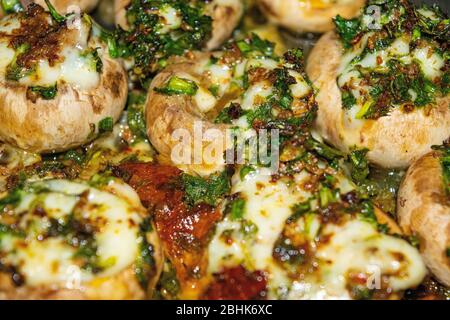 Im Ofen gebackene Pilze mit Käse, grünen Zwiebeln und Dill. Nahaufnahme Stockfoto