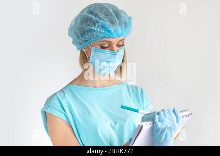 Junge Ärztin, die einen medizinischen Bericht auf einem Clipboard schreibt, medizinische Fachkräfte auf weißem Hintergrund. Gesundheitskonzept Stockfoto