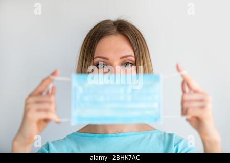Arzt oder Krankenschwester hält in der Hand Nahaufnahme Gesichtsmaske auf weißem Hintergrund. Konzentriere dich auf die Frau. Gesundheits- und medizinisches Konzept, um die Ausbreitung des vir zu verhindern Stockfoto
