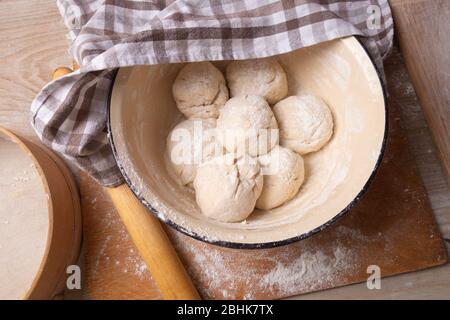 Teigkugeln sind in einer großen gelben Schüssel. Kochen zu Hause Stockfoto