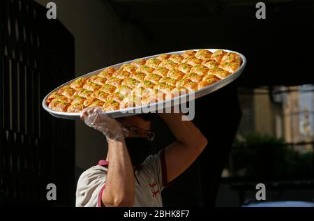 Beirut, Libanon. April 2020. Ein Verkäufer bereitet während des Ramadan inmitten der COVID-19-Pandemie in Beirut, Libanon, am 26. April 2020 Süßigkeiten zu. Die Zahl der COVID-19-Infektionen im Libanon stieg am Sonntag um drei Fälle auf 707 an, während die Zahl der Todesopfer unverändert bei 24 blieb, berichtete die Nationale Nachrichtenagentur. Kredit: Bilal Jawich/Xinhua/Alamy Live News Stockfoto