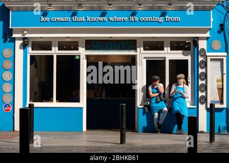 Murphy's Eiscrememitarbeiter warten auf Kunden und bieten Touristen auf der Main Street in Killarney, County Kerry, Irland, kostenlose Eisproben an Stockfoto