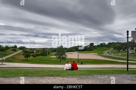 Ein Paar Mann und Frau sitzen auf dem Rasen im Battlefield National Park in Quebec City. Stockfoto