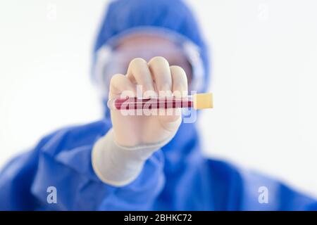 Blutprobe durch NHS-Mitarbeiter mit blauer voller PSA während der COVid19-Pandemiekrise Stockfoto