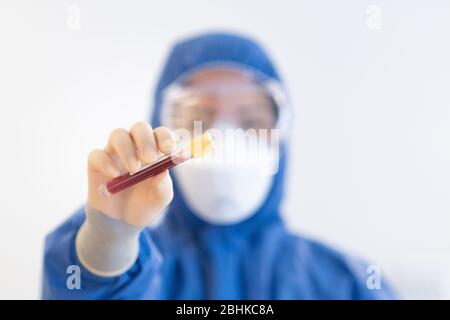 Blutprobe durch NHS-Mitarbeiter mit blauer voller PSA während der COVid19-Pandemiekrise Stockfoto