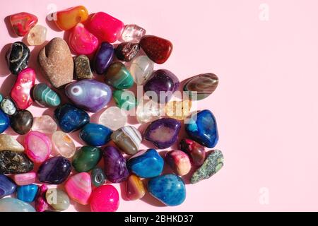 Bunte polierte Mineralien auf rosa Hintergrund. Stockfoto