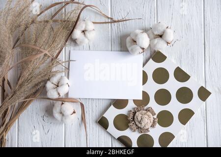 Mock up mit Baumwollblumen und getrockneten Blumen auf einem hellen Holzhintergrund. Rustikaler Rahmen für Text mit getrockneten Kräutern und Blumen Stockfoto