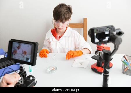 9-jähriger Junge macht pädagogisches Video über chemische Experimente Für seinen Vlog Stockfoto