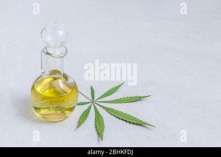 Cannabis CBD Öl in Glasflasche mit Marihuana Blatt auf neutralem Licht Hintergrund mit Platz für Text Stockfoto