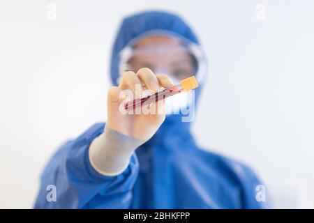 Blutprobe durch NHS-Mitarbeiter mit blauer voller PSA während der COVid19-Pandemiekrise Stockfoto