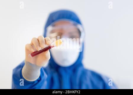 Blutprobe durch NHS-Mitarbeiter mit blauer voller PSA während der COVid19-Pandemiekrise Stockfoto