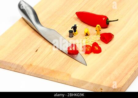 Food Konzept der Miniatur Figur Menschen tragen Hasmat Anzüge Inspektion rote Chili-Paprika Stockfoto