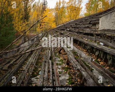 Verlassene verfallende Tribüne des Sportstadions Avangard, von der Natur in der Geisterstadt Pripjat in der Tschernobyl-Ausschlusszone aufgenommen. Ukraine Stockfoto