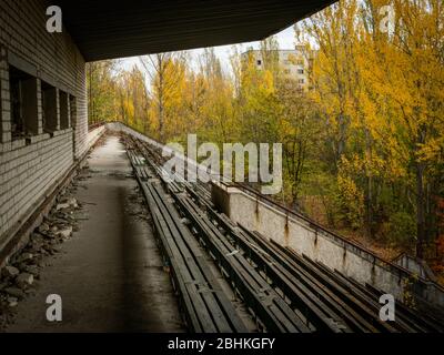 Verlassene verfallende Tribüne des Sportstadions Avangard, von der Natur in der Geisterstadt Pripjat in der Tschernobyl-Ausschlusszone aufgenommen. Ukraine Stockfoto