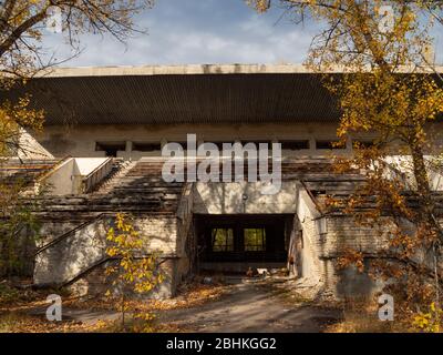 Verlassene Tribüne des Sportstadions Avangard, aufgenommen von der Natur in der Geisterstadt Pripjat in der Tschernobyl-Ausschlusszone. Ukraine Stockfoto