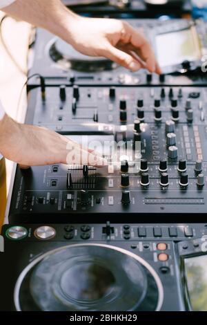 DJ spielt Musik am Strand. DJ Mixing Beach Party im Sommerurlaub im Freien. Disc Jockey Hände spielen Musik für Touristen. Hand eines Deejays Stockfoto