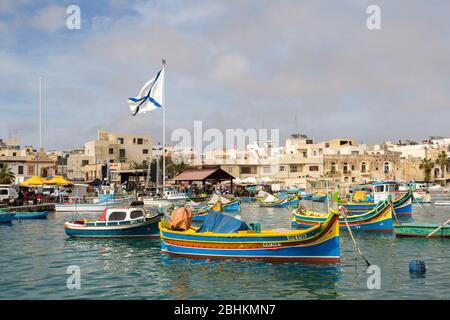 Hafen mit Booten und maltesischer Flagge in Marsaxlokk, Malta Stockfoto