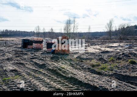 Verstärkungsstäbe ragen aus dem Boden an einem Ort, wo es Betonpfosten, der Anfang des Hauses Rohre. Stockfoto