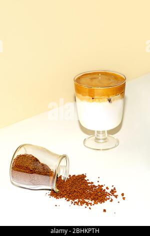 Eine Tasse eisgekühlter Dalgona Kaffee, modischer flauschiger cremiger Schlagkaffee auf einem trendigen farbigen Hintergrund. Stockfoto