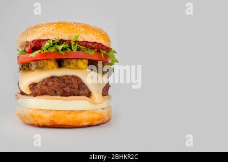 Ein großer großer klassischer Hamburger Cheeseburger isoliert auf grauem Hintergrund mit Kopierfläche Stockfoto