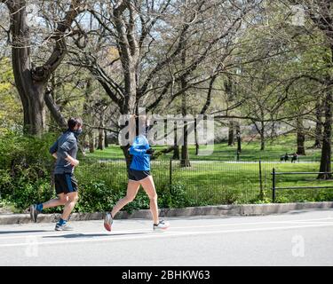 Läufer mit Masken im Central Park, New York während der Coronavirus Pandemie. Stockfoto