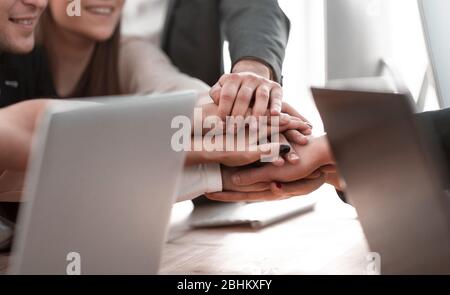 Nahaufnahme. Junge Mitarbeiter machen ihnen einen Turm aus der Hand Stockfoto