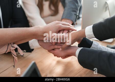 Nahaufnahme. Junge Mitarbeiter machen ihnen einen Turm aus der Hand Stockfoto