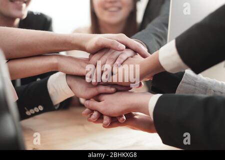 Nahaufnahme. Junge Mitarbeiter machen ihnen einen Turm aus der Hand Stockfoto