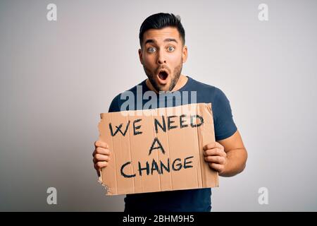 Der junge, gutaussehende Aktivist, der gegen den beneidensartigen Papphobel protestiert, der mit einem Überraschungsgesicht erschreckt wurde, fürchtet und mit Angst Expressi aufgeregt wurde Stockfoto