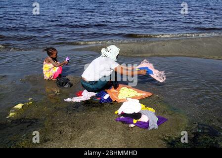 Mutter und Tochter waschen Kleidung an den Ufern des Lake Abijatta Stockfoto