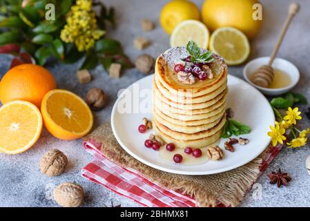 Köstliche frische schöne Pfannkuchen mit Zitrushonig und Marmelade. Leckeres warmes Frühstück mit Pfannkuchen mit Obst und Beeren Stockfoto