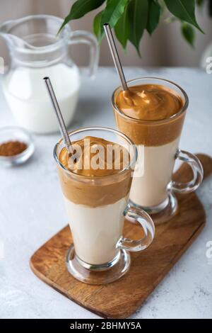 Zwei Dalgona-Kaffee aus Milch und Instant-Kaffee auf einem hellen Hintergrund. Selektiver Fokus Stockfoto