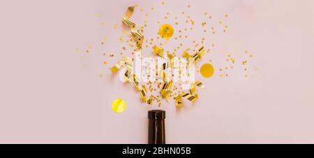 Goldene Streamer, Pailletten, goldene Spiralen und Sterne explodieren und fliegen wie ein Feuerwerk aus dem Hals einer Flasche dunkles Glas. Gratulationsbanner Stockfoto