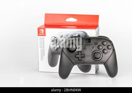 Riga, Lettland - April 24 ,2020: Nintendo Pro Controller mit Box für Nintendo Switch, schwarze Konsole für Spieler auf weißem Hintergrund Stockfoto