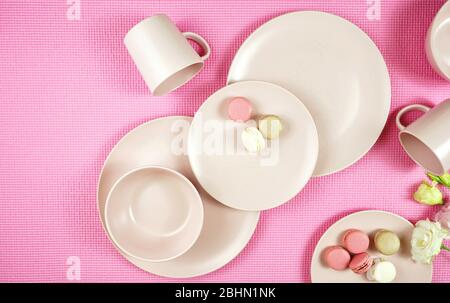 Draufsicht auf modernes, in Pastellrosa gefertigter Keramikgeschirr auf rosafarbenem Boden. Kreatives Konzept Kochen, Küche flat Layout mit negativem Kopierplatz. Stockfoto