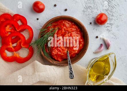 Ajvar Gemüsepfeffer Kaviar in einer Schüssel auf einem hellen Hintergrund. Balkanküche. Blick von oben Stockfoto