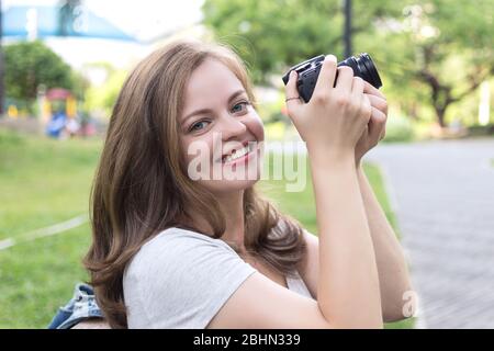 Junge kaukasische Frau Mädchen Fotograf hält eine Digitalkamera in den Händen, ein Foto oder Video Stockfoto