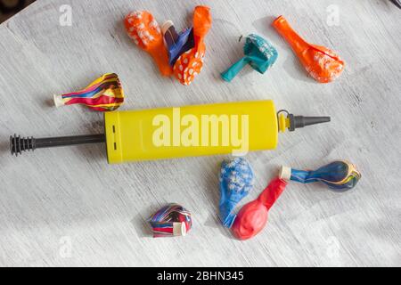 Gelbe Pumpe zum Blasen von Ballons mit lebhaften Ballons auf einem Tisch Stockfoto