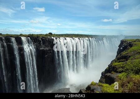 Victoria Falls oder "Mosi-Oa-Tunya" (der Rauch, der donnert) und Sambesi, Simbabwe / Sambia Grenze, Südliches Afrika Stockfoto